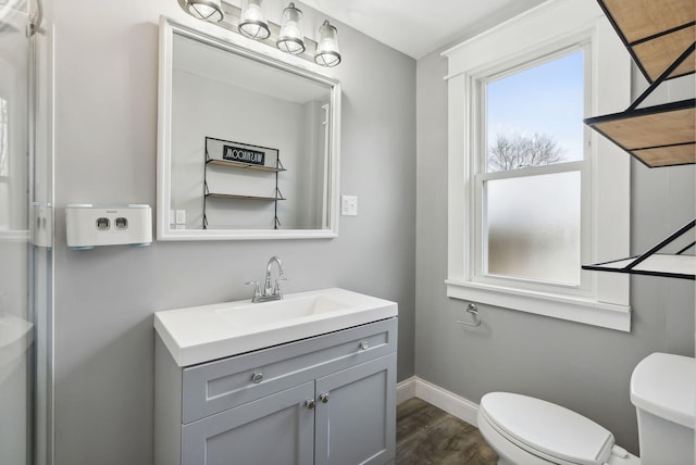 bathroom with toilet, vanity, and hardwood / wood-style flooring