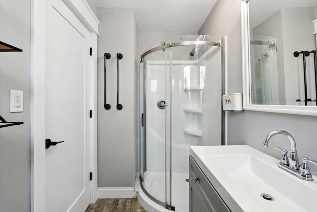 bathroom with vanity, hardwood / wood-style flooring, and a shower with door