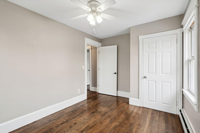 unfurnished bedroom featuring ceiling fan, dark hardwood / wood-style flooring, and baseboard heating