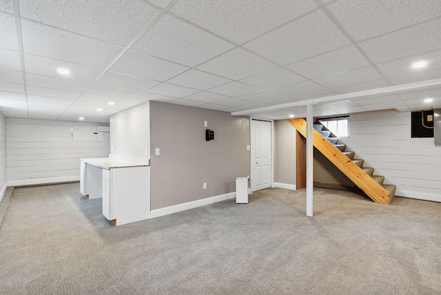 basement with carpet floors and a paneled ceiling