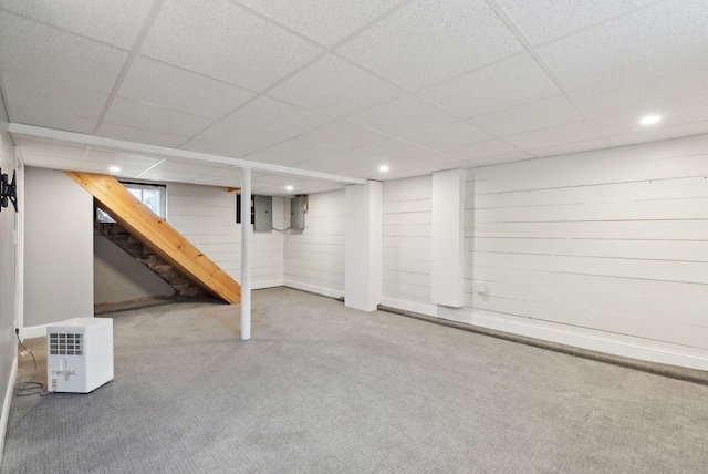 basement featuring a paneled ceiling and carpet