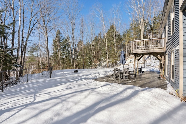 yard layered in snow with outdoor dining area and a patio