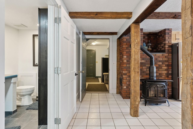 hall with beamed ceiling, visible vents, and light tile patterned floors