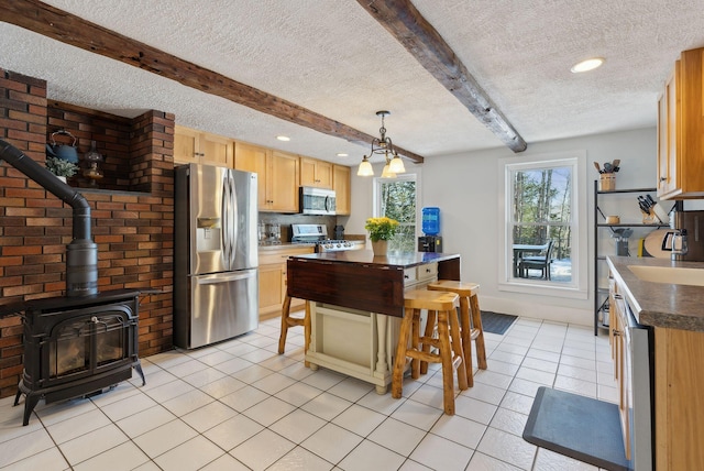 kitchen featuring beamed ceiling, a textured ceiling, appliances with stainless steel finishes, and light tile patterned floors
