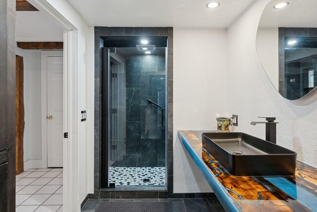 bathroom featuring recessed lighting, a shower stall, tile patterned floors, a sink, and baseboards