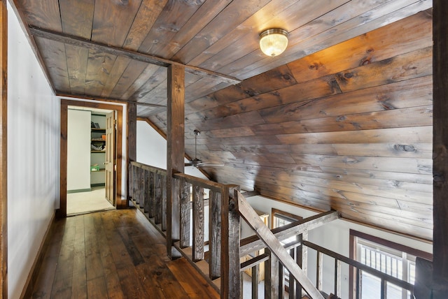 corridor with vaulted ceiling, an upstairs landing, wood ceiling, baseboards, and dark wood-style flooring