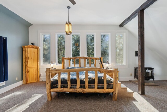 bedroom with baseboards, carpet floors, and a wood stove