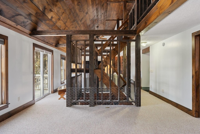 stairway with wooden ceiling, baseboards, and carpet