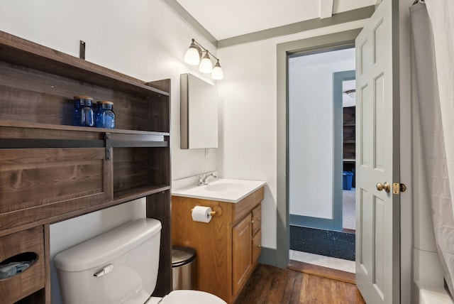 bathroom featuring wood finished floors, vanity, and toilet