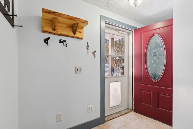 entrance foyer with light tile patterned flooring and a textured ceiling