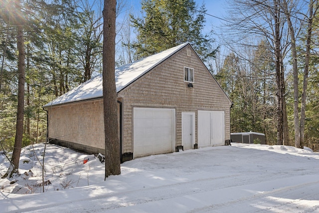 snow covered garage featuring a garage
