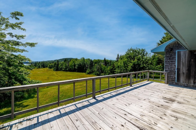 wooden deck featuring a lawn