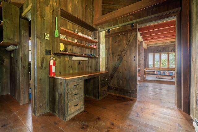 bar featuring hardwood / wood-style floors, a barn door, and wooden walls