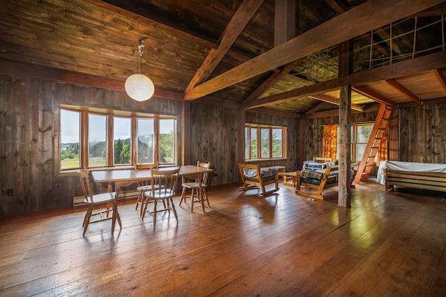 dining space with wood walls, dark hardwood / wood-style flooring, and vaulted ceiling with beams