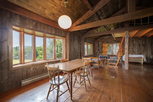 dining area featuring wooden walls, lofted ceiling with beams, and plenty of natural light