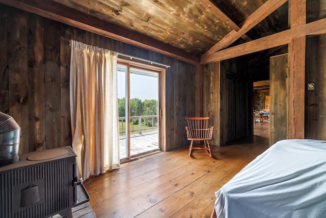 bedroom featuring vaulted ceiling with beams, access to exterior, wood ceiling, wooden walls, and wood-type flooring