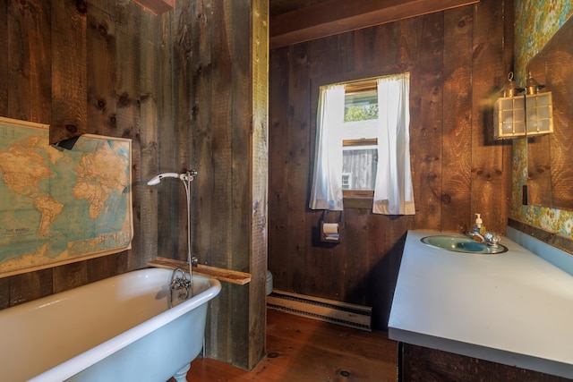 bathroom featuring a baseboard radiator, a washtub, toilet, wooden walls, and vanity