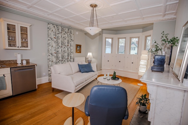 living room featuring coffered ceiling and light hardwood / wood-style floors