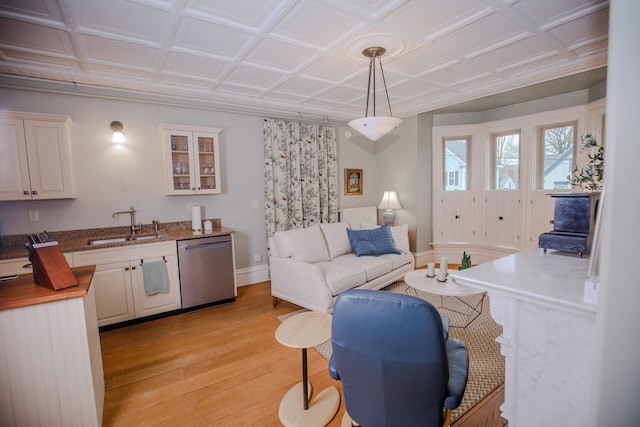 living room featuring coffered ceiling, sink, and light hardwood / wood-style floors