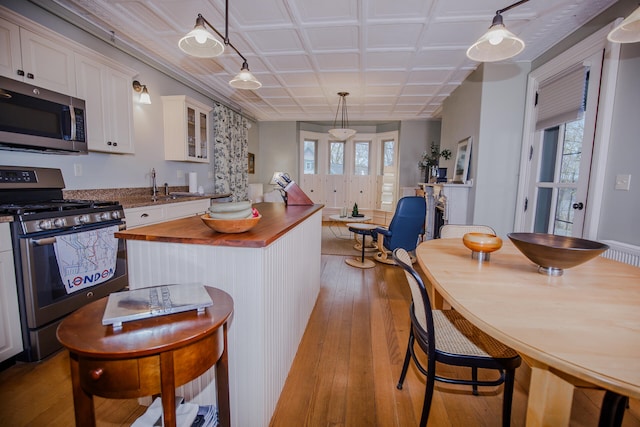 kitchen with appliances with stainless steel finishes, white cabinetry, and a wealth of natural light