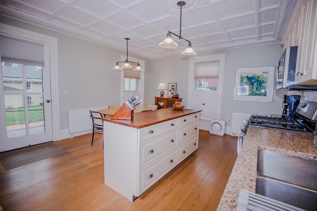 kitchen with white cabinetry, light wood-type flooring, and plenty of natural light