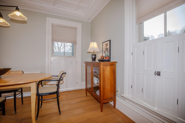 dining area featuring crown molding and light hardwood / wood-style flooring