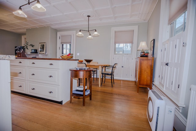 kitchen with a wealth of natural light, light wood-type flooring, and white cabinets