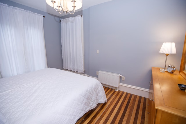 bedroom with radiator heating unit and an inviting chandelier