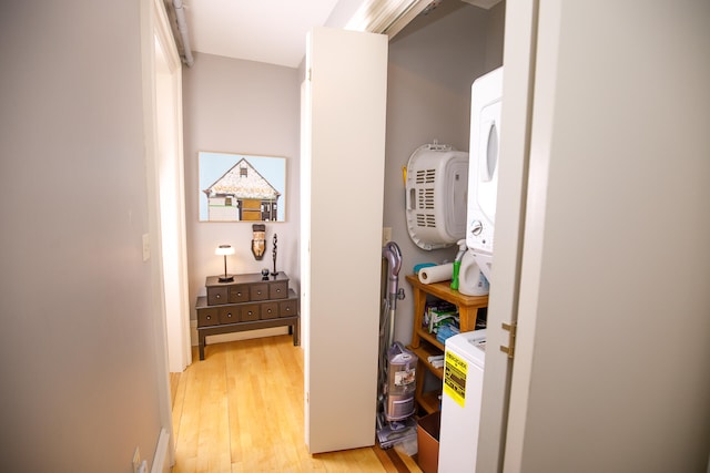 clothes washing area with stacked washer and dryer and light hardwood / wood-style flooring