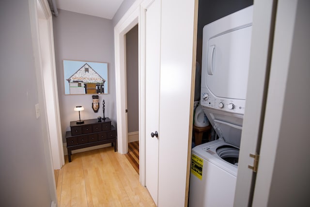 clothes washing area featuring stacked washer / drying machine and light hardwood / wood-style floors