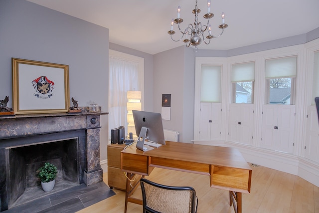 office with light hardwood / wood-style floors and a chandelier