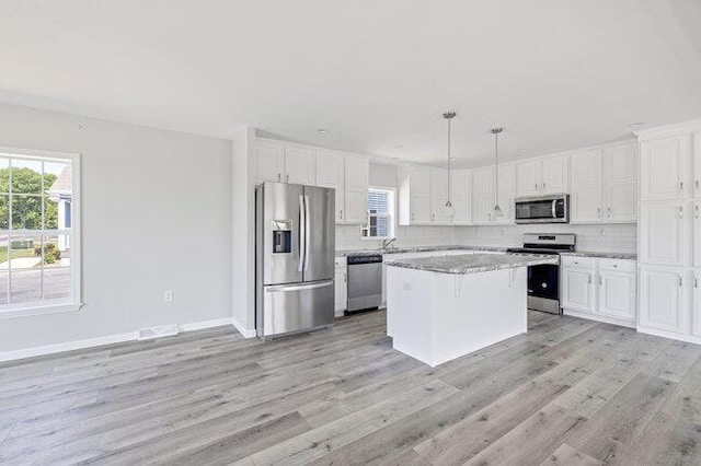 kitchen featuring light wood-style flooring, tasteful backsplash, appliances with stainless steel finishes, and white cabinetry