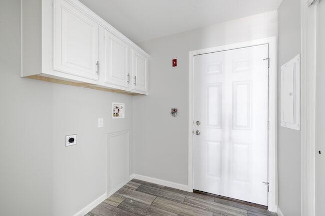 laundry area featuring electric dryer hookup, baseboards, dark wood finished floors, hookup for a washing machine, and cabinet space