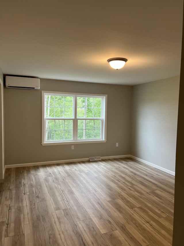10 Mathew Way, Scarborough, ME 04074 - unfurnished room with an AC wall unit and wood finished floors