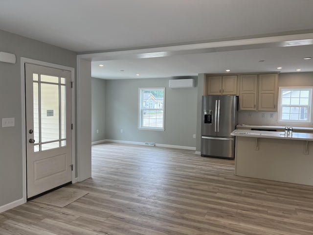 10 Mathew Way, Scarborough, ME 04074 - kitchen with stainless steel fridge, a wall unit AC, light wood-style floors, light countertops, and healthy amount of natural light