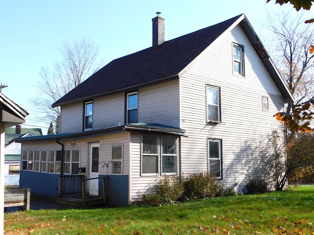 rear view of property featuring a lawn