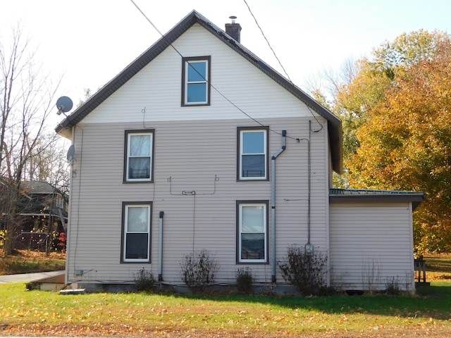 back of property featuring a lawn