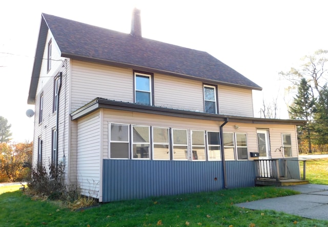 rear view of property featuring a yard