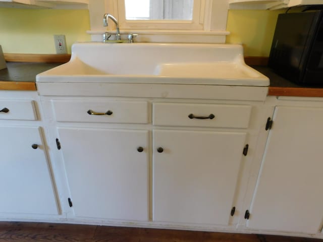 interior details with white cabinetry and sink