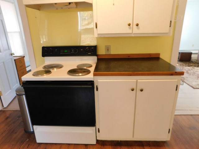 kitchen with white cabinets, dark hardwood / wood-style flooring, and white range with electric stovetop