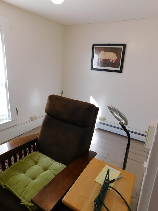 bedroom featuring light wood-type flooring and a baseboard heating unit