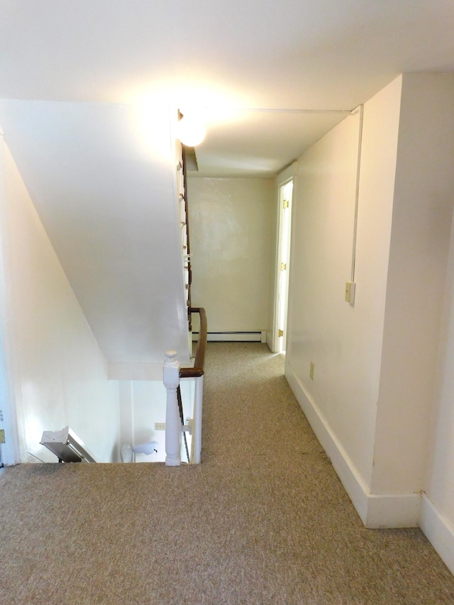 hallway featuring light colored carpet and baseboard heating