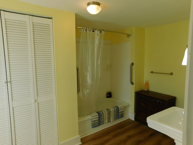 bathroom with hardwood / wood-style floors and shower / bath combo with shower curtain