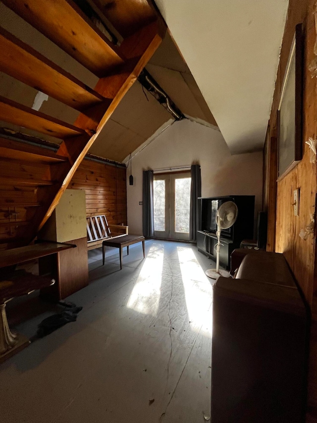 game room featuring lofted ceiling, wood walls, and french doors