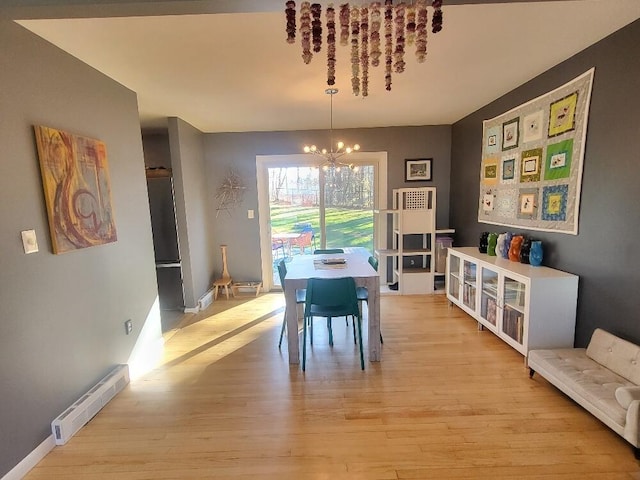 dining room featuring light wood-style floors, baseboards, a baseboard heating unit, and a notable chandelier