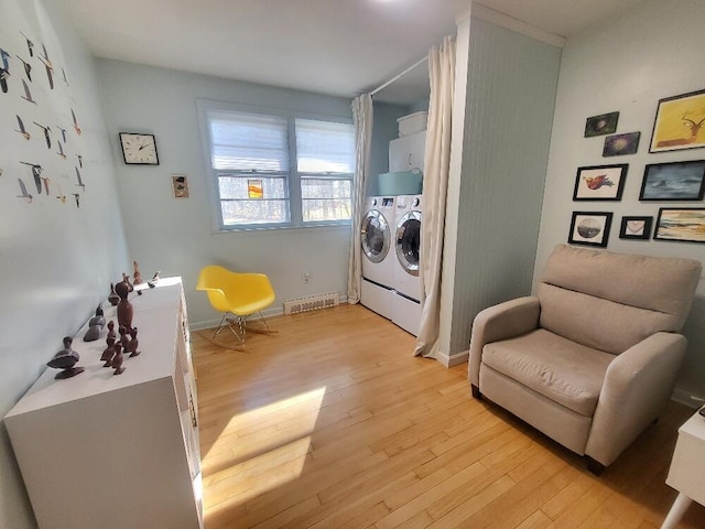 living area featuring baseboards, washing machine and dryer, visible vents, and light wood-style floors