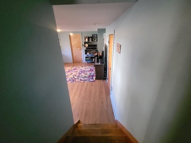 hallway featuring baseboards and light wood finished floors