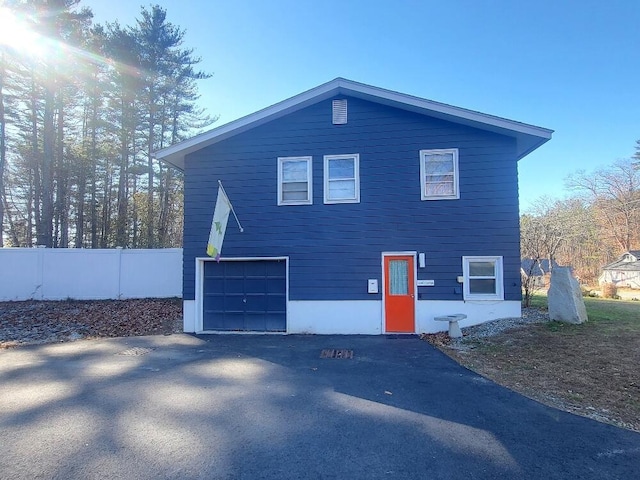 view of side of property featuring fence and aphalt driveway