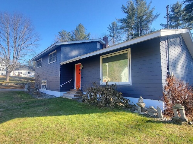 view of front of home with a chimney and a front yard