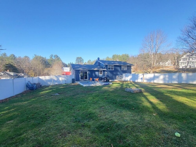 rear view of property with a fenced backyard, a patio, and a yard